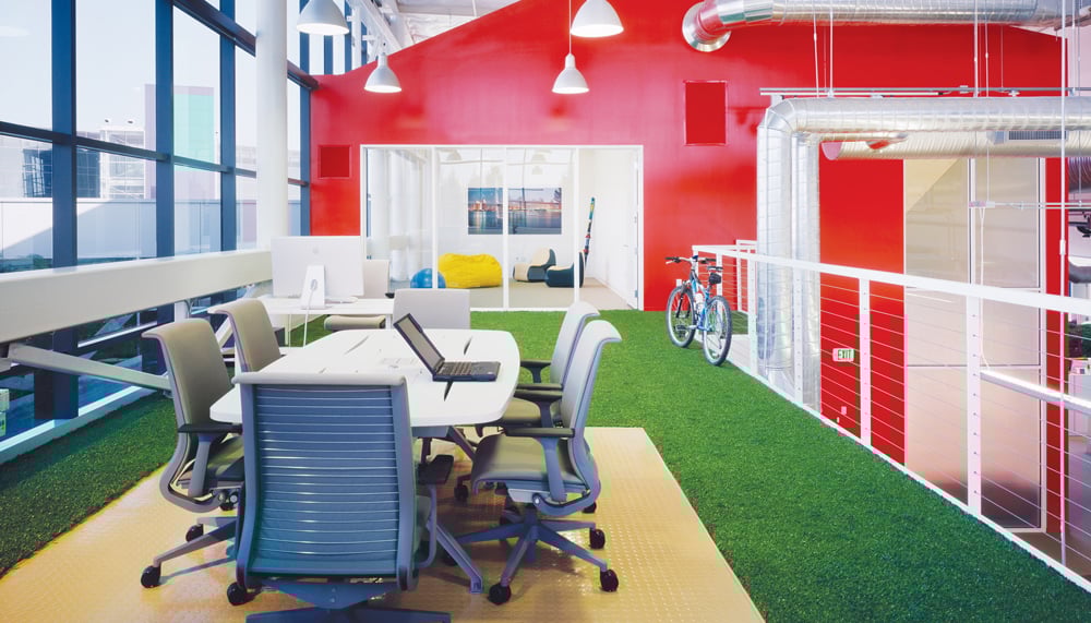 Googleplex astro turf office with red walls and meeting table